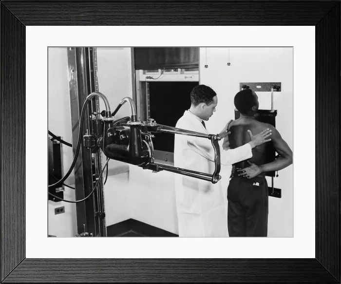Framed Print : African American doctor placing patient in the correct position for taking chest x-ray for use in the diagnosis in 1937 Framed Print : African American doctor placing patient in the correct position for taking chest x-ray for use in the diagnosis in 1937