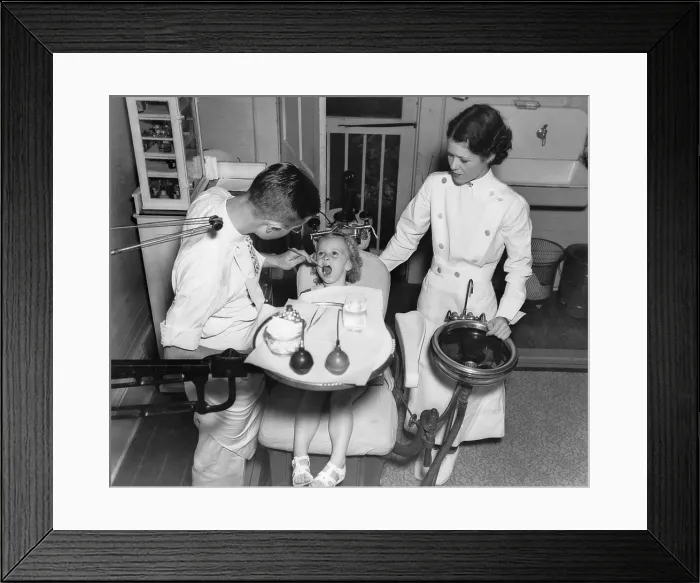 Framed Print : A dentist examining a young girl's teeth in 1942