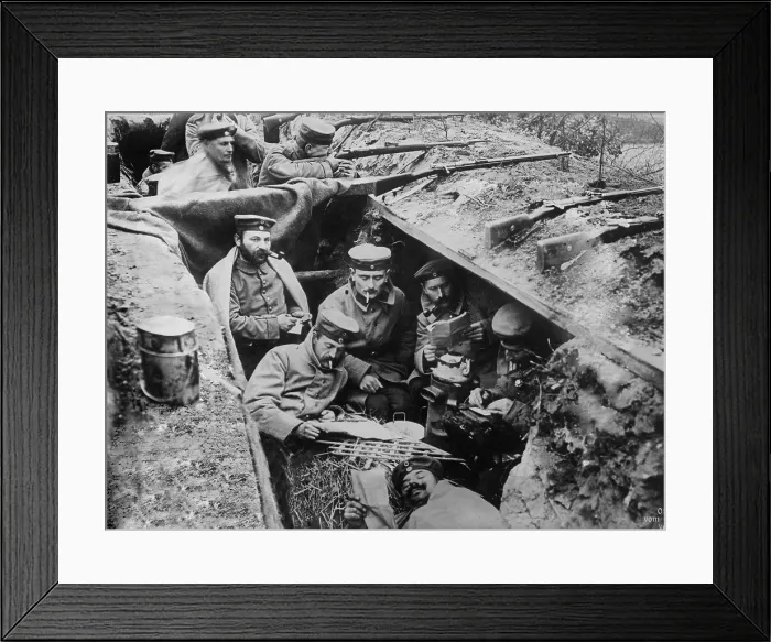 Framed Print : World War 1. German soldiers smoking, reading, and writing in their trench. In the background one soldier maintains a battle position. Western Front, ca. 1914-15