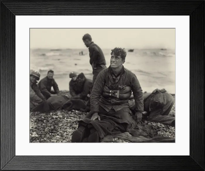 Framed Print : World War II. American soldiers on Omaha Beach recovering the dead after the D-Day invasion of France. June 1944, by U.S. Army Signal Corps photographer, Walter Roseblum