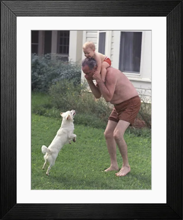 Framed Print : President Lyndon Johnson and grandson, Lyn Nugent, play with dog Yuki at the LBJ Ranch. August 1968