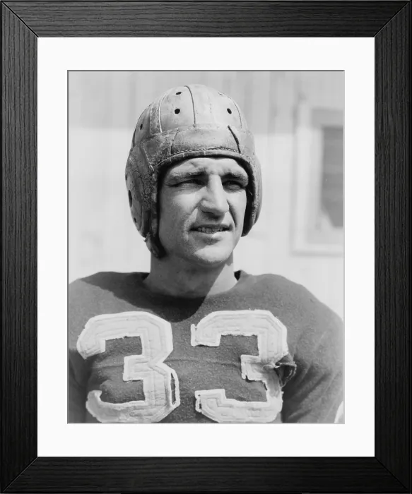 Framed Print : Sammy Baugh (1914-2008), wearing a tattered football jersey and helmet, 1938. He played in the National Football League for the Washington Redskins from 1937 to 1952