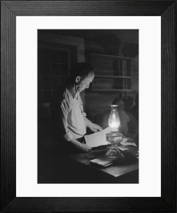 Framed Print : Man reading by the light of a kerosene lantern. The petroleum product, replaced whale oil in the 19th century, was the standard lighting fuel before electricity