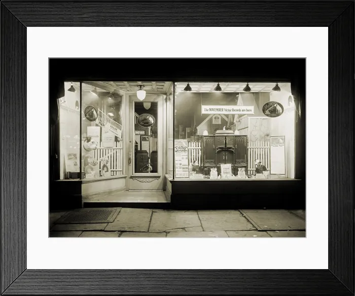 Framed Print : Graham's Shop in New York City is dominated by the Victor brand, displaying many versions of the trademark dog