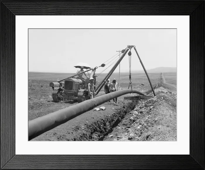 Framed Print : Dropping a welded pipe into a trench with a crane while laying the Iraq Petroleum Company's pipe line across Palestine's Plain of Esdraelon, July 1933 Framed Print : Dropping a welded pipe into a trench with a crane while laying the Iraq Petroleum Company's pipe line across Palestine's Plain of Esdraelon, July 1933