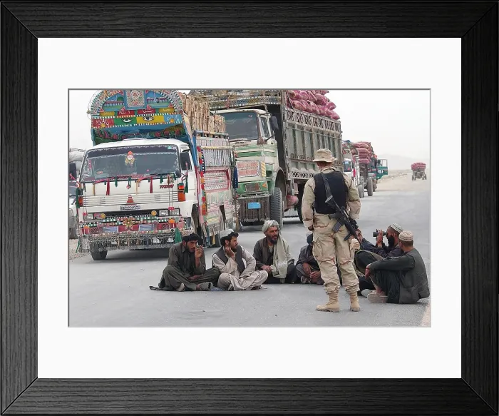 Framed Print : A U.S. Army soldier with Afghani men while they wait at a safe distance from 3 000 pounds of bombs detonated outside the perimeter of Kandahar Air Base