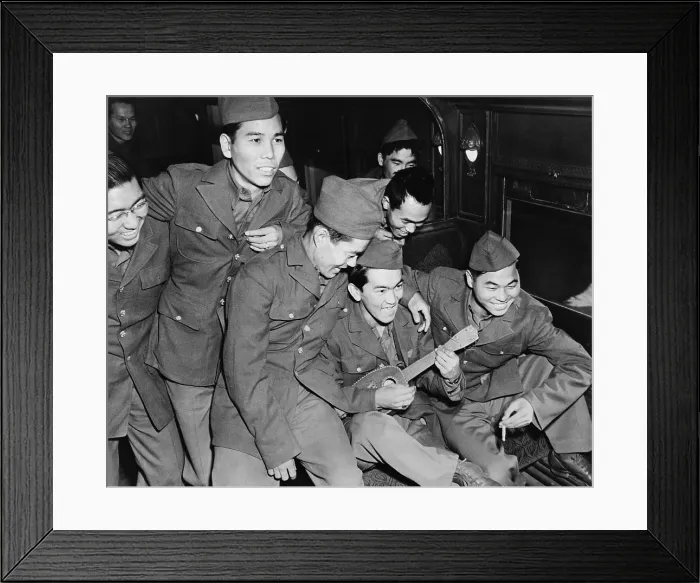 Framed Print : Japanese American soldiers enjoy the music of a Hawaiian ukulele as they wait to detrain at Camp Shelby, Mississippi in 1943