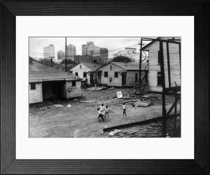 Framed Print : African American children playing in slum in view of high rise buildings in background. North Carolina, ca. 1966