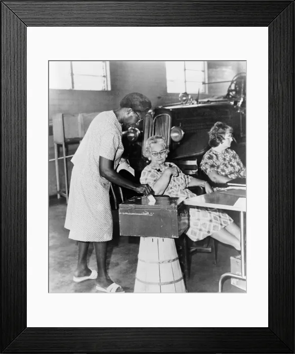 Framed Print : African-American woman placing ballot in box during congressional primary election in Jackson, Mississippi. 1965