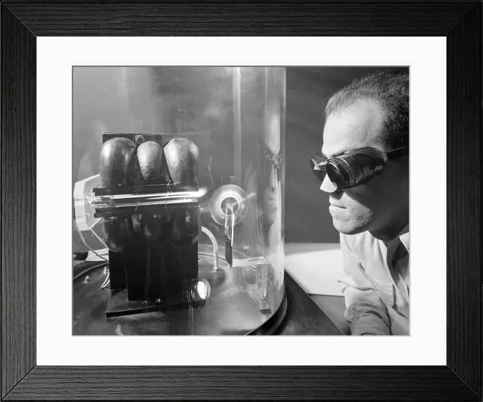Framed Print : Scientist with protective glasses and nose cover experimenting with Ion Jet rocket propulsion. Sept. 27, 1957
