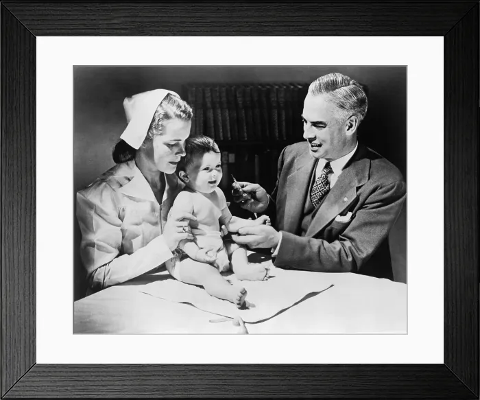 Framed Print : Nurse holding an infant as a doctor prepares to immunize the child against influenza. 1958
