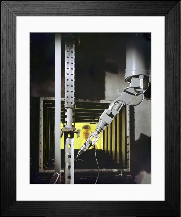 Framed Print : A nuclear engineer is protected from radiation by a fifty-two inch thick oil-filled, glass window as he operates a robotic arm