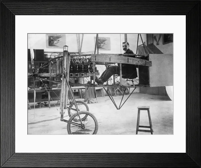 Framed Print : Louis Bleriot 1872-1936 seated in his 50 horse power mono-plane which is under construction in his workshop. LC-USZ62-107352