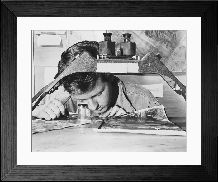Framed Print : U.S. Air Force Sergeant studies an reconnaissance photo of a Communist gun position