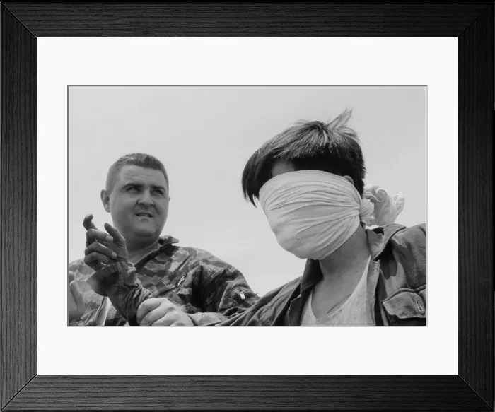 Framed Print : Blindfolded Viet Cong POW. US Marine Sergeant guides a blindfolded POW in Quang Tri Province, during the first significant action between US and Viet Cong Forces