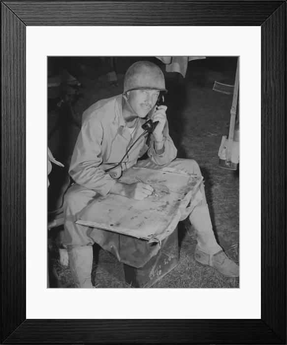 Framed Print : Lt. Col. Raymond Murray taking a message over field phone and plotting positions on a map, August 23, 1950