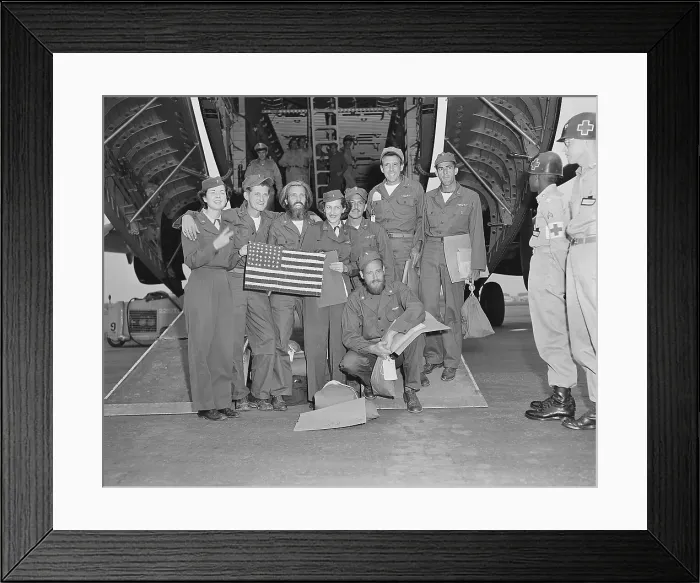 Framed Print : Released POWs, a B-29 crew pose with their flight nurses at Tachikawa Air Base, Japan. They made the American flag during 33 months in a North Korean POW camp