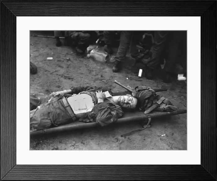 Framed Print : U.S. 21st Infantry soldier lies on a stretcher at a medical aid station