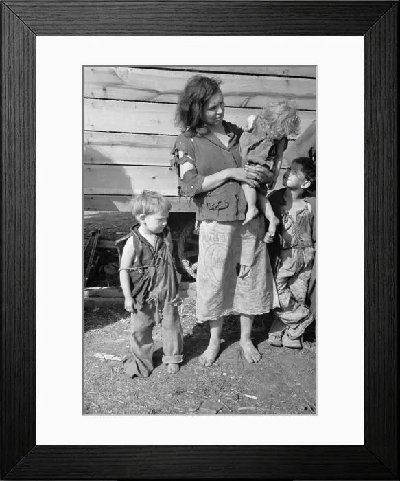Framed Print : Young mother dressed in a ragged sweater and a skirt made of a flour sack with three children also dressed in rags