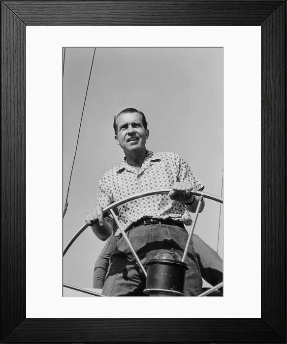 Framed Print : President Richard Nixon behind the wheel on of a boat. Ca. 1969-74