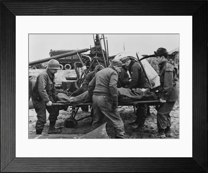 Framed Print : Medics carry a wounded U.S. soldier away from a rescue helicopter