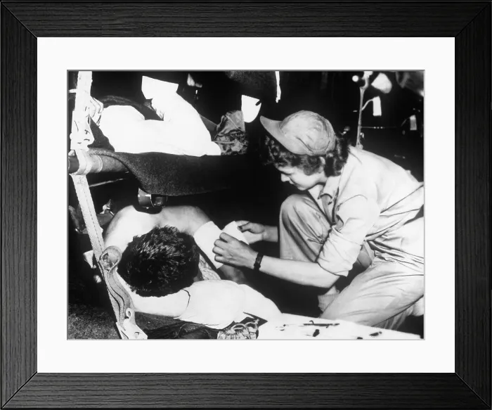 Framed Print : U.S. flight nurse dresses a soldier's wound during the flight from Korea to Japan, May 1951. Korean War, 1950-53. (BSLOC_2014_11_202)