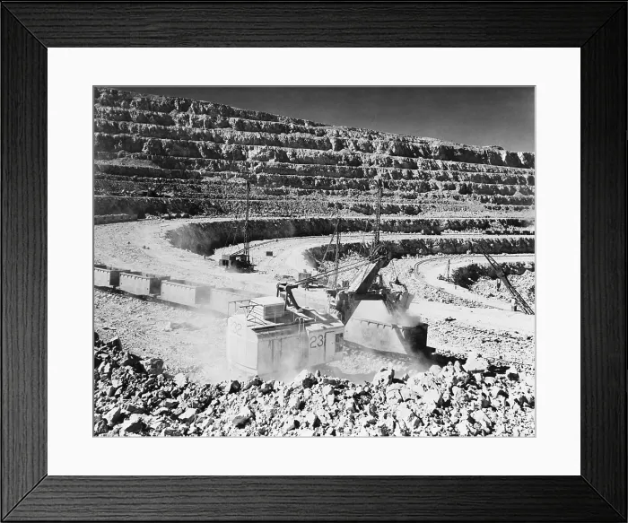 Framed Print : Open pit copper mine at Chuquicamata, Chile. Photo shows a crane steam shovel strip mining raw copper ore and depositing it into open railroad cars. Ca. 1945