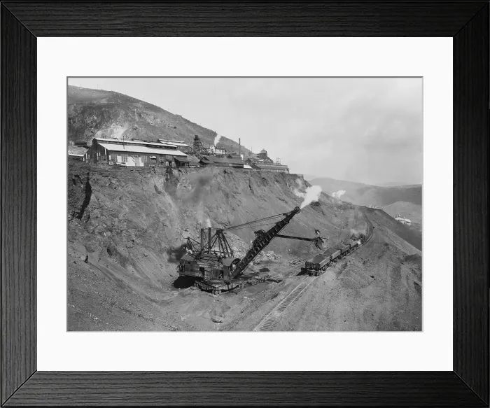 Framed Print : Open pit United Verde Mine on mountain side in Jerome, Arizona. Photo shows a crane strip mining raw copper ore and depositing it into open railroad cars. Ca. 1915
