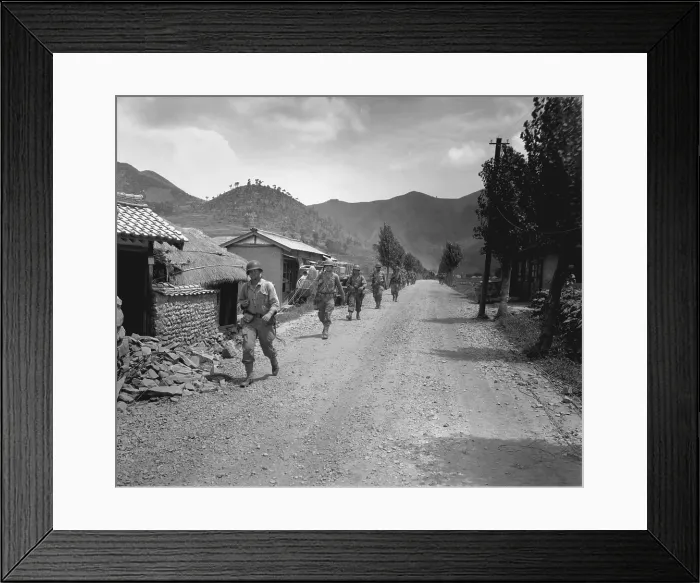 Framed Print : U.S. Marines pass through one of the many small, battered South Korean villages. They are moving up to meet the North Korean forces during the Battle of Pusan Perimeter