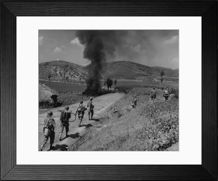 Framed Print : U.S. Marines advancing in the Naktong River Battle, Sept. 4, 1950. The men in the column are spaced out to avoid casualties and walk around the burning North Korean tank Framed Print : U.S. Marines advancing in the Naktong River Battle, Sept. 4, 1950. The men in the column are spaced out to avoid casualties and walk around the burning North Korean tank