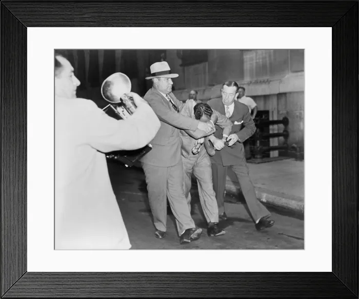 Framed Print : Two policemen forcibly escorting Vincent Jimmy Blue Eyes Ado (1904-2001), after appearing in lineup; a news photographer (left) foreground captures the scene