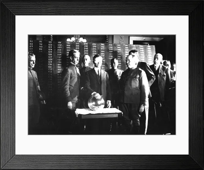 Framed Print : Secretary of War Newton D. Baker, wearing a blindfold, initiates the second draft of World War I. He draws the first number, 246, out of a glass bowl to start the draft Framed Print : Secretary of War Newton D. Baker, wearing a blindfold, initiates the second draft of World War I. He draws the first number, 246, out of a glass bowl to start the draft
