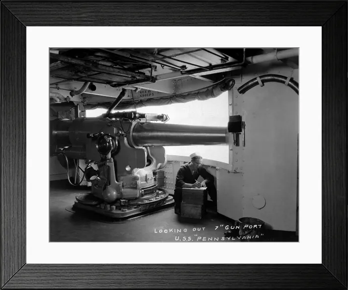 Framed Print : Looking out 7 inch gun port, USS Pennsylvania. She was a U.S. Navy super-dreadnought battleship. The sailor writing beside the gun indicates it large size. World War I. Ca. 1918
