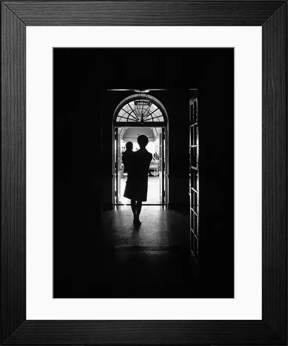 Framed Print : Silhouette portrait of Jacqueline Kennedy carrying her one year old son John Kennedy Jr. in the White House, South Portico Entrance. Nov. 30, 1962