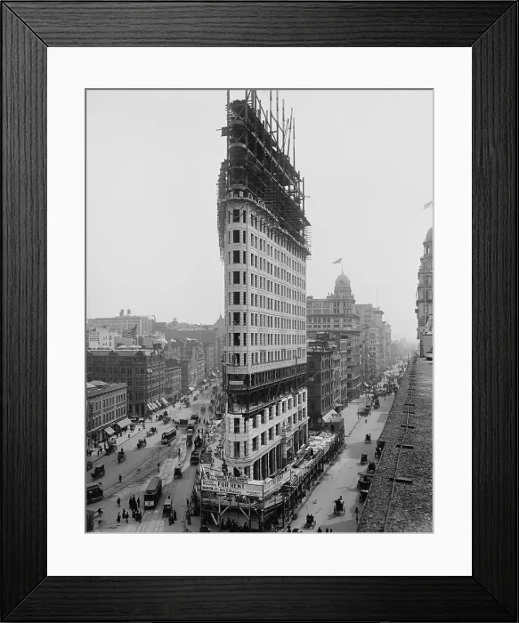 Framed Print : Flatiron Building during construction in 1902. The steel frame construction, a rectangular grid of I-beams, ascends above the stone facing