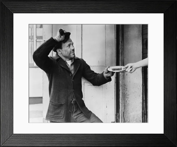 Framed Print : A Hobo, Lou Ambers, tips his hat as he accepts a sandwich from a woman's hand during the Great Depression