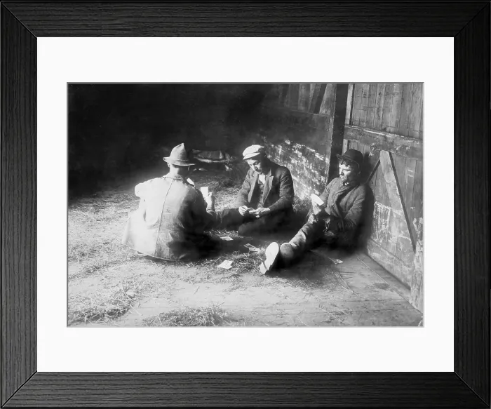 Framed Print : Tramps traveling in a freight car pass the time playing cards. Migrant laborers hopped box cars to seek work. Ca. 1910