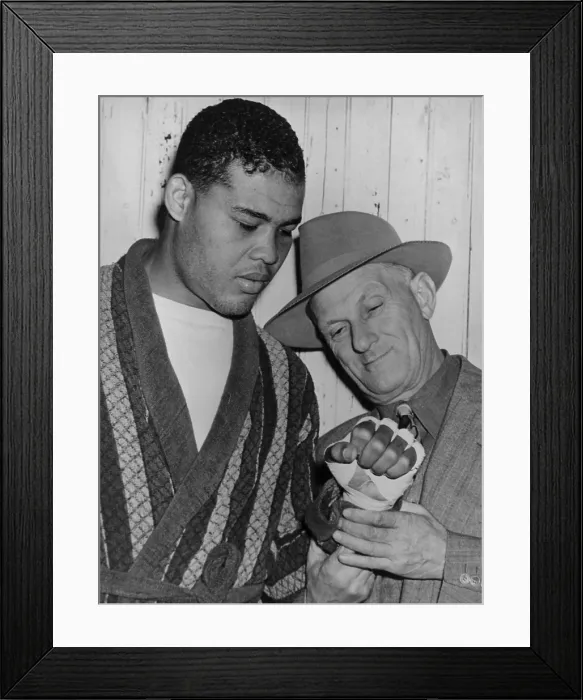 Framed Print : Mike Jacobs inspects Joe Louis fist before the heavy weight champion would defend his title against Lou Nova on Sept. 29, 1941