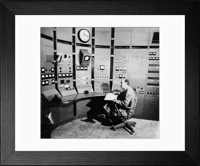 Framed Print : Enrico Fermi (1901-1954), seated at control panel of a particle accelerator, in 1951