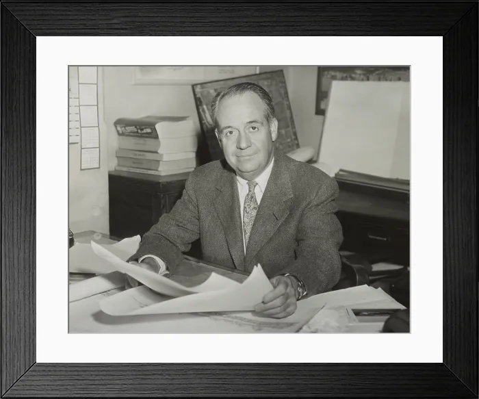 Framed Print : Robert Trent Jones, golf course architect, sitting at desk and holding drawings in 1953. - (BSLOC_2015_1_122)