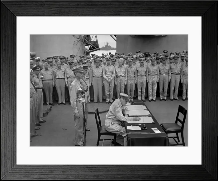 Framed Print : Douglas MacArthur signs documents during Japanese surrender ceremonies on the USS MISSOURI in Tokyo Bay. Standing behind MacArthur are Gen. Jonathan Wainwright and British Gen