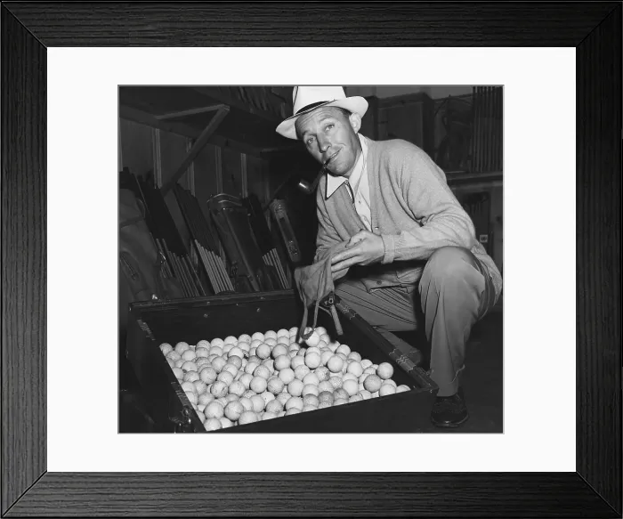 Framed Print : Bing Crosby contributes his golf balls the World War 2 scrap rubber drive. Ca. 1943. (BSLOC_2013-12_137)