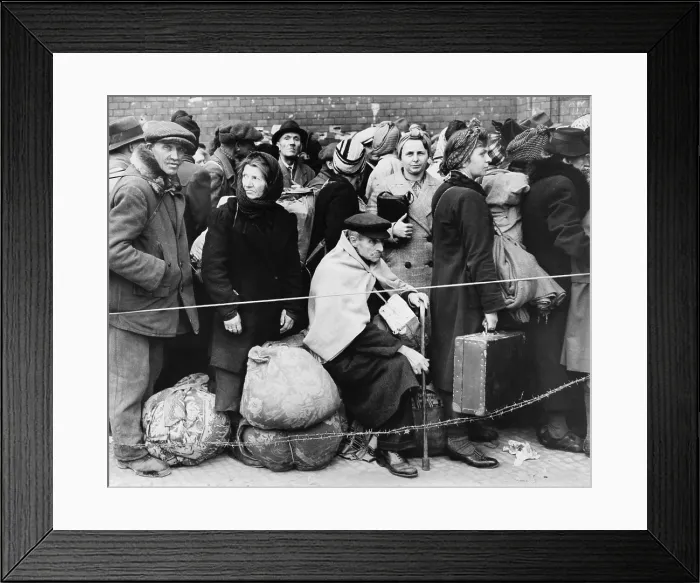 Framed Print : German displaced persons wait in Berlin's Anhalter Station in 1945. Refugees are carrying their few belongings, as the stand behind a rope and double strand of barbed wire