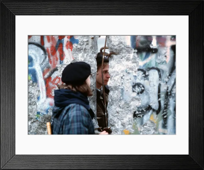 Framed Print : A young West German woman speaks with an East German guard through an opening in the Berlin Wall. Dec. 21 1989. (BSLOC_2011_3_54)