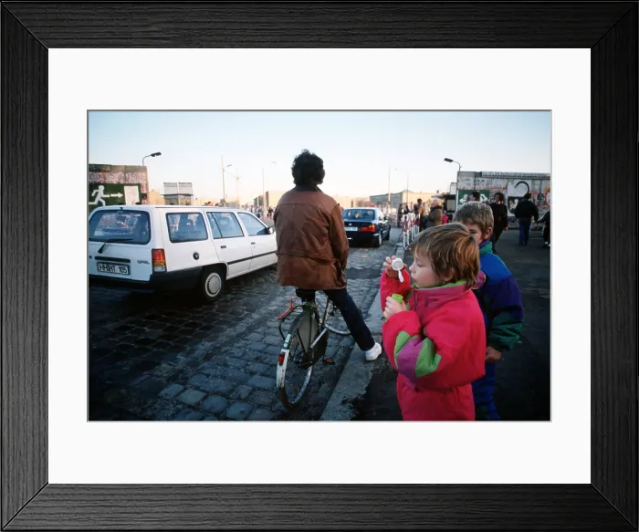 Framed Print : A child blows bubbles as carsfreely cross the border of East and West Berlin at Potsdamer Platz. Dec. 21 1989. (BSLOC_2011_3_55)