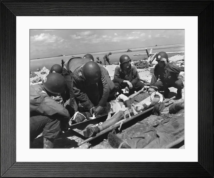 Framed Print : Marine on the stretcher at a dressing station on Tarawa smokes as he is attended by medics. He has a wounded arm and leg. Nov. 20-23, 1943 during World War 2. (BSLOC_2013_14_254)