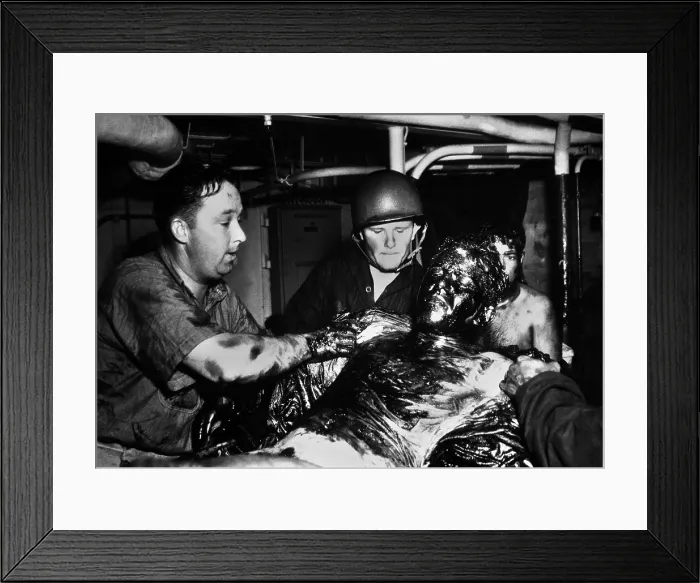 Framed Print : Coast Guardsmen scrape a thick coating of oil from the body of U.S. Navy seaman Framed Print : Coast Guardsmen scrape a thick coating of oil from the body of U.S. Navy seaman