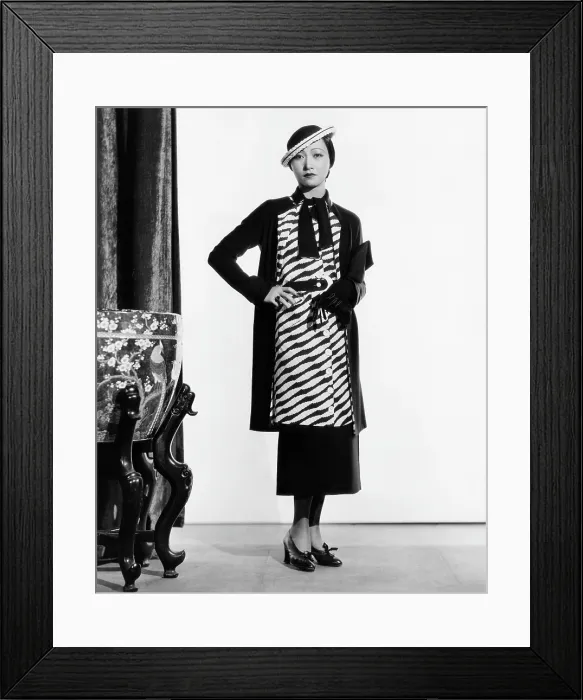 Framed Print : LIMEHOUSE BLUES, (aka EAST END CHANT), Anna May Wong, in a navy-and-white silk suit and straw hat, 1934