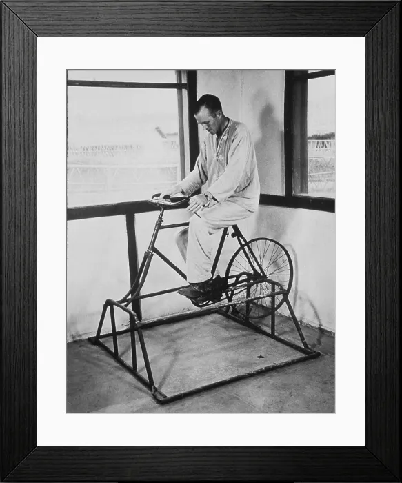 Framed Print : Physical therapy patient using stationary bicycle. Ca. 1950