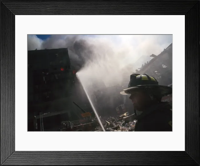 Framed Print : Fire fighter at World Trade Center site following September 11th terrorist attack. In the center background is the burning pile of the collapsed WTC 1 (North Tower) Framed Print : Fire fighter at World Trade Center site following September 11th terrorist attack. In the center background is the burning pile of the collapsed WTC 1 (North Tower)